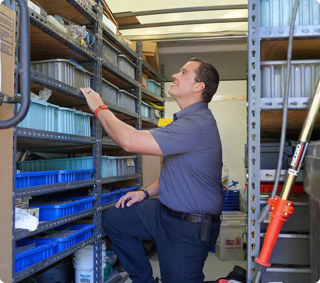 Technician reaching for parts on warehouse shelving