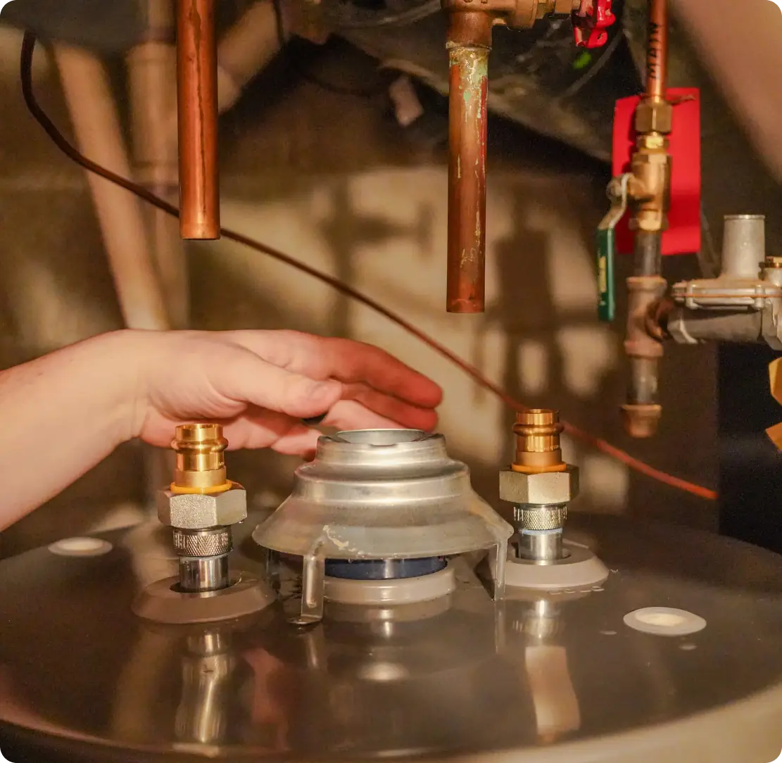 Plumber checking water heater connections and valves